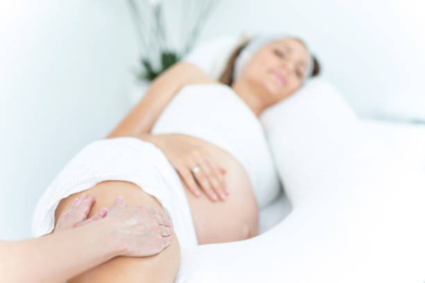 pregnant woman receiving a leg massage. - reiki alternative therapy massaging women imagens e fotografias de stock