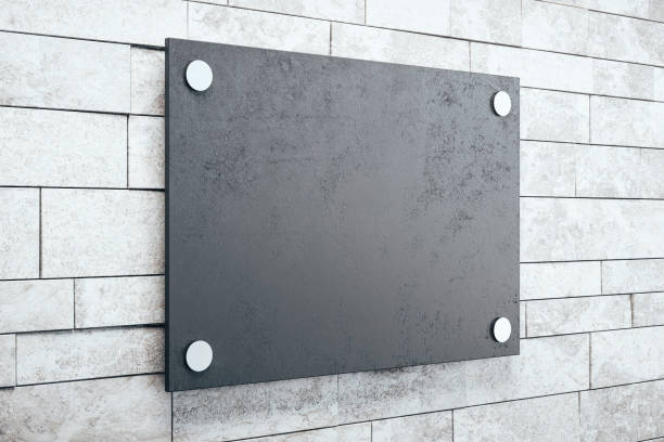 istock Side view of black glass plate on brick wall background. 1257843532