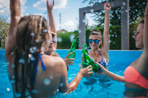 istock Young women drinking beer at the pool 1257843942