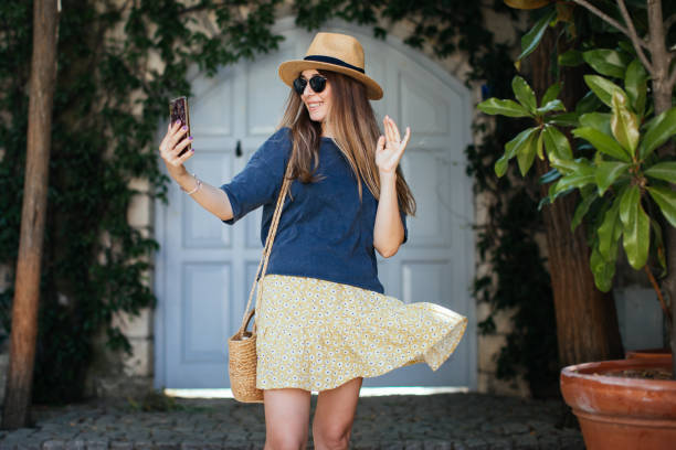 istock Attractive young woman making self portrait while standing in the city 1257845430
