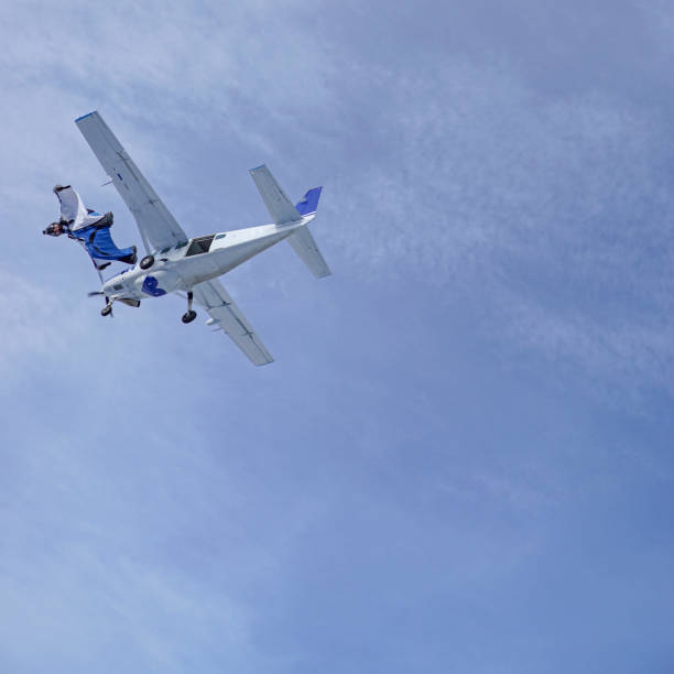 istock Wing suit soars through clear blue skies 1257845520