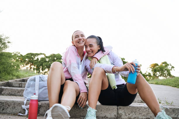 istock Cheerful loving sisters embracing each other after training while relaxing 1257846488