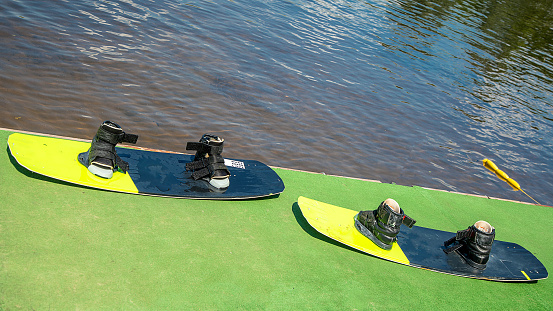 two wakeboards stand by the water. Preparing for the wakeboarding. Sports equipment, summer time, sports lifestyle. Activity in Wake park