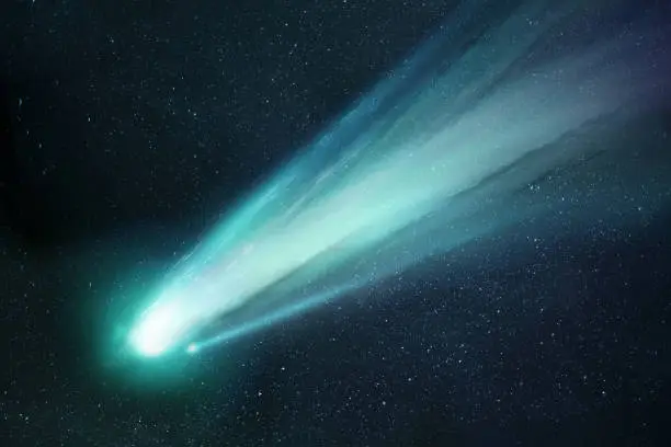 Comet Neowise passing the sun and releasing gases creating a tail and coma. Illustration.