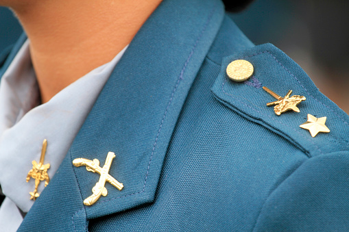 This is a close up horizontal, color photograph of a United States Navy officer's decorated dress uniform.