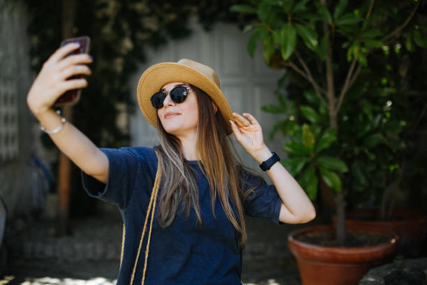 istock Attractive young woman making self portrait while standing in the city 1257848302