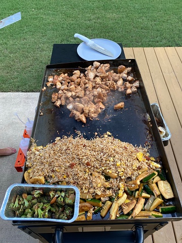 Chicken, fried rice and vegetables on a grill