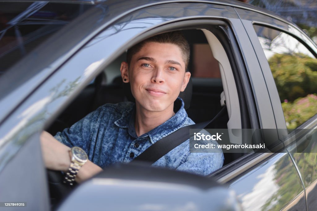 Portrait of young man driving a car Driver's License Stock Photo