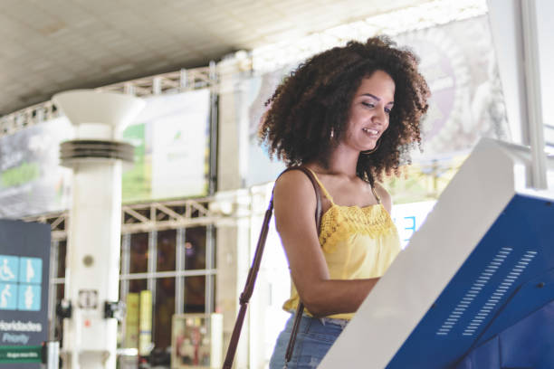 jovem usando autoatendimento no aeroporto - pessoa do check in - fotografias e filmes do acervo