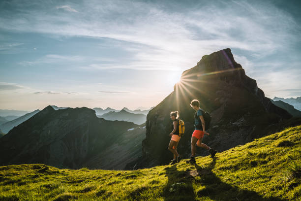 Trail runners ascend high mountain ridge Above distant mountains and valleys schwyz stock pictures, royalty-free photos & images
