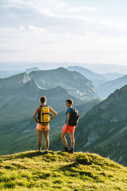 biegacze wznoszą się wysoko górzystym grzbietem - hiking young women outdoors t shirt zdjęcia i obrazy z banku zdjęć