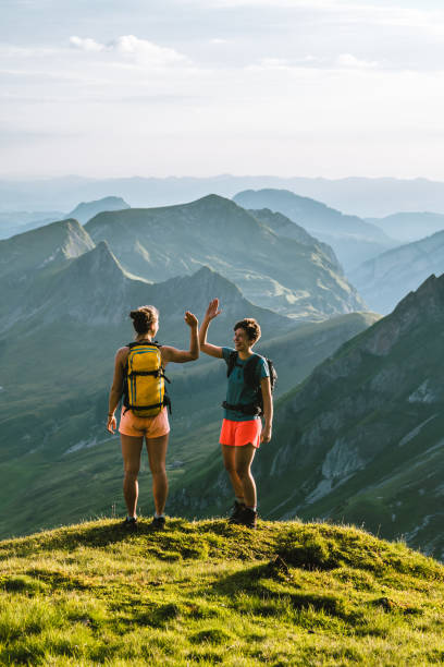 biegacze wznoszą się wysoko górzystym grzbietem - hiking young women outdoors t shirt zdjęcia i obrazy z banku zdjęć