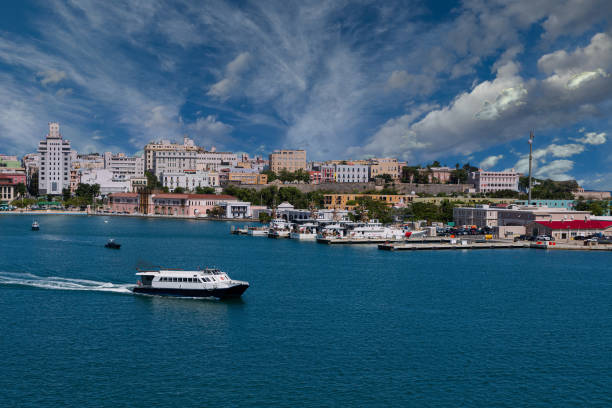 Blue container ship in the bay of San Juan passing the historic fortress walls of El Morro in Puerto Rico