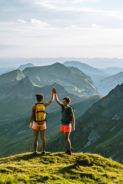 бегуны по тропе поднимаются на высокий горный хребет - hiking young women outdoors t shirt стоковые фото и изображения