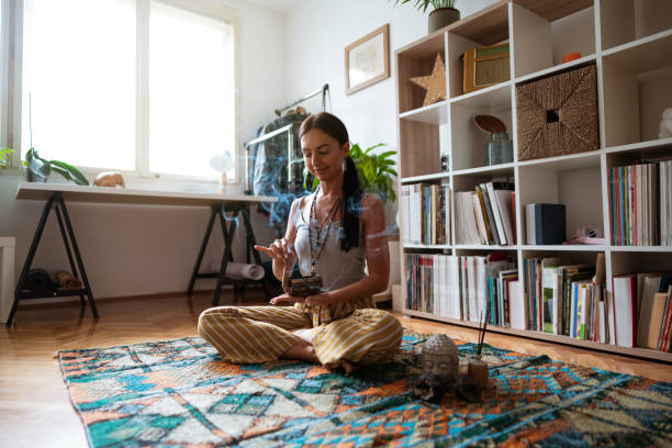 istock Smiling young woman using meditation bell at home and relaxing 1257852181