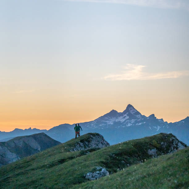 istock Trail runners ascend high mountain ridge 1257853623