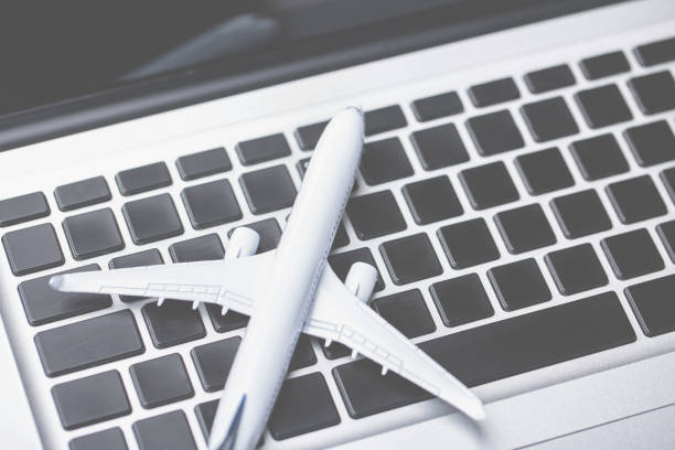 istock Plane on laptop keyboard. Booking tickets online 1257853813