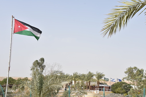 National flags of Jordan and Israel on national border at Jordan River