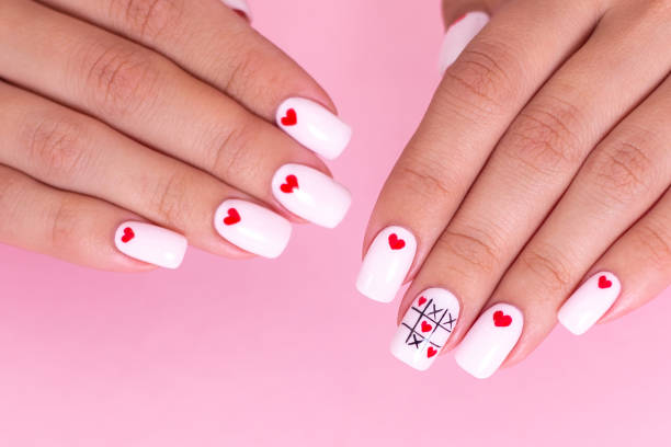istock Beautiful female hands with white manicure, hearts design 1257855097