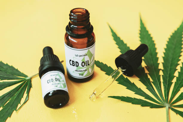 CBD oil, Cannabis oil on yellow background. CBD oil and cannabis leaf on yellow background. cbd oil photos stock pictures, royalty-free photos & images
