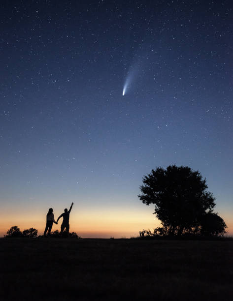 istock Young couple watching the Neowise comet under the bright night sky 1257859733