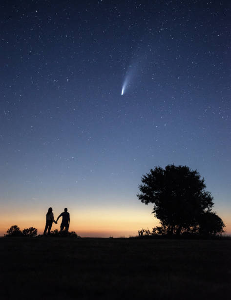 istock Young couple watching the Neowise comet under the bright night sky 1257859744