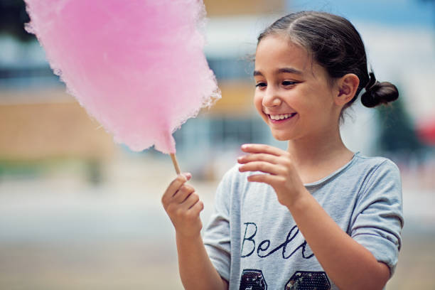 Portrait of little girl eating cotton candy Portrait of little girl eating cotton candy child cotton candy stock pictures, royalty-free photos & images