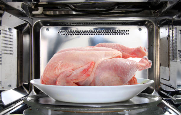 rã đông gà nguyên con bằng lò vi sóng - defrost chicken in microwave hình ảnh sẵn có, bức ảnh & hình ảnh trả phí bản quyền một lần