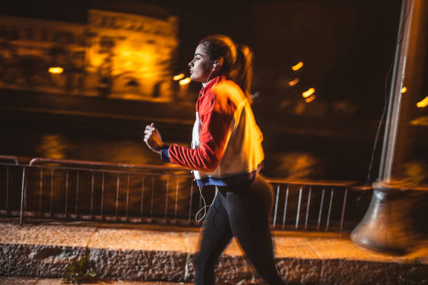 istock Young female athlete running on sidewalk near river 1257861756