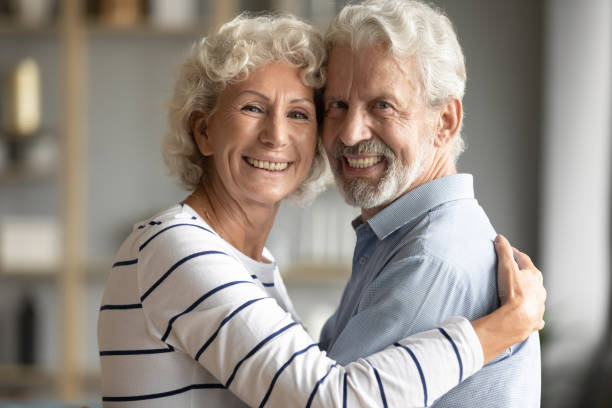 istock Head shot portrait happy older couple hugging, looking at camera 1257866103