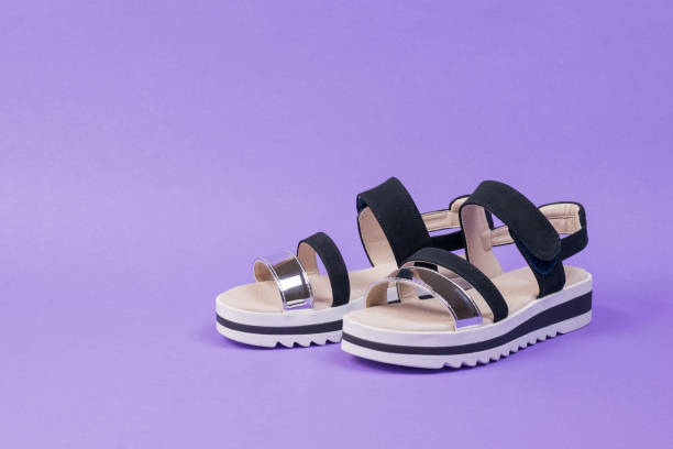 istock Stylish women's summer sandals on a rich lilac background. 1257878145