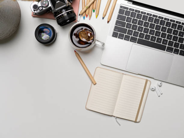 istock Workspace with laptop, stationery, camera, accessories and copy space on white desk 1257879542