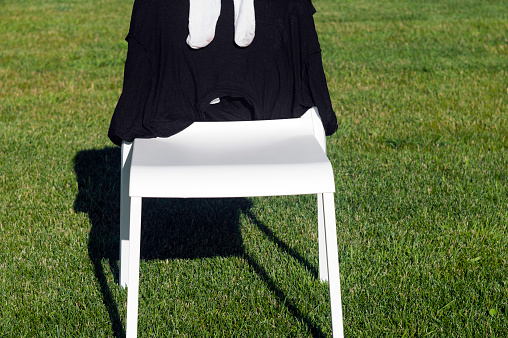 Socks and t-shirt drying on a chair, placed on the lawn