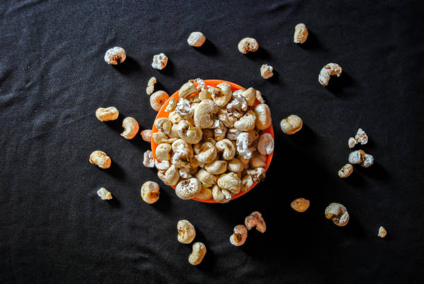 istock Pop corn in an orange bowl isolated on black background 1257887444