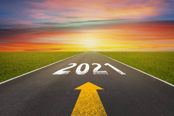 istock Empty asphalt street road and writing text 2021 on roadway. 1257889980