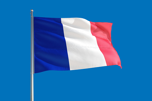 France national flag waving in the wind on a deep blue sky. High quality fabric. International relations concept.