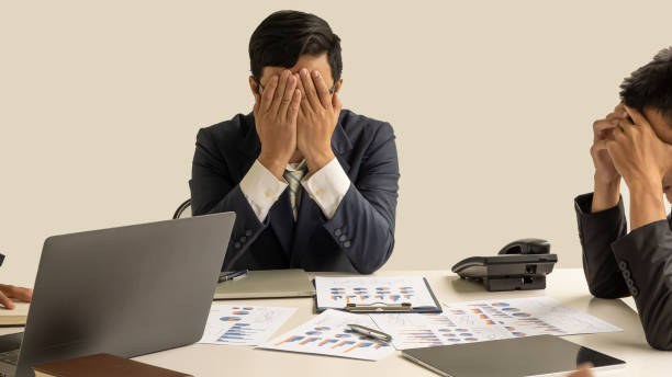 istock The young business man turned his head off and looked for a solution and on the table full of graphs and computers. 1257896209