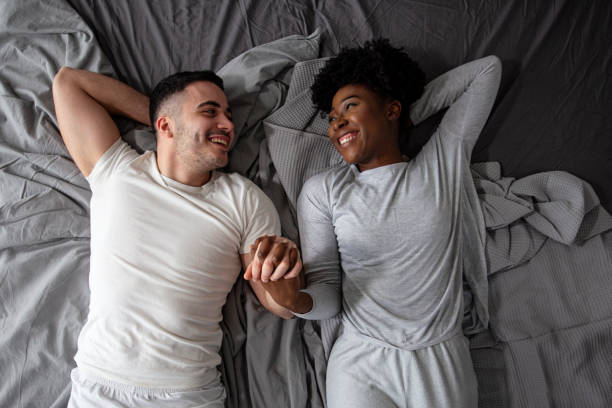 istock Multiethnic couple lying in bed and looking each other and smile 1257896846