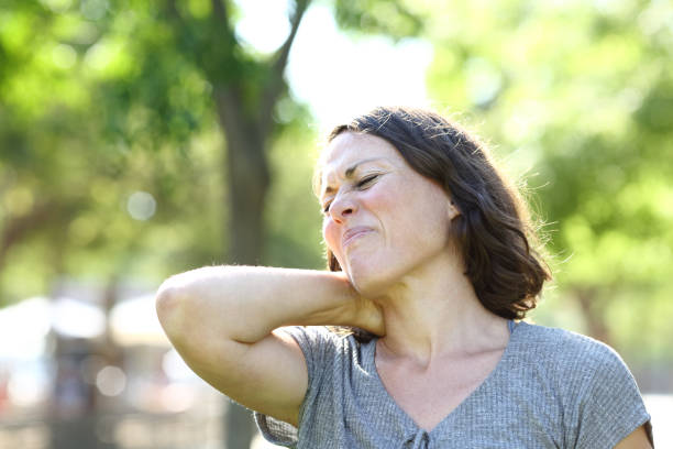 istock Middle age woman suffering neck ache in a park 1257897670