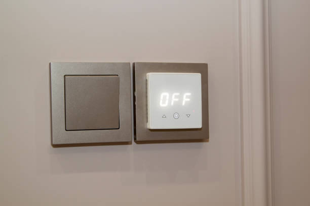 istock Close up view of electric light switch and sensor for floor heating on an empty wall 1257899912