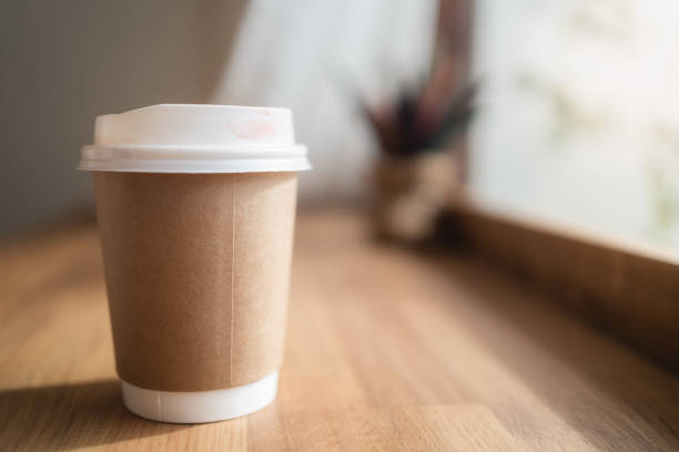 istock Take away coffee cup with lipstick mark on wooden table in small coffee cafe 1257901971