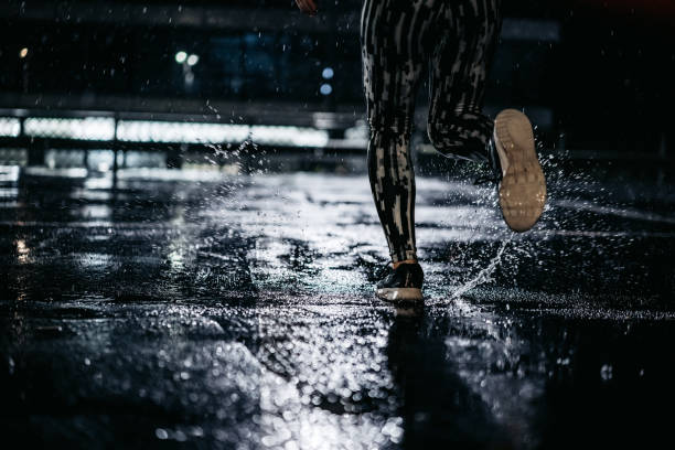 running in the rain - night running imagens e fotografias de stock