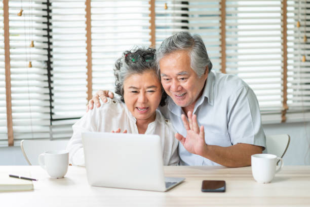 Elderly Couple making video chat on laptop at home