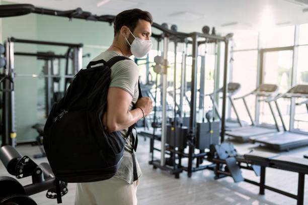 istock Athletic man with protective face mask entering the gym. 1257903845