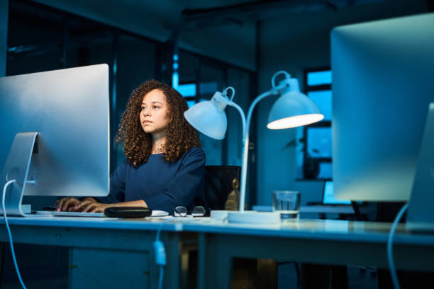 istock Young businesswoman working on a computer in an office at night 1257909879