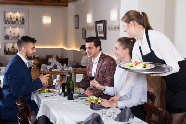 istock Waitress serving meals to company at restaurant 1257911624