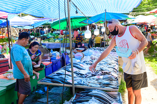 Phuket, Thailand - July 20, 2020 : Tourists choosing fresh fish at flea market in Phuket during covid-19 quarantine.