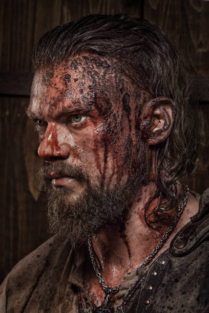 istock Weapon wielding bloody young viking warrior in studio shot 1257912894