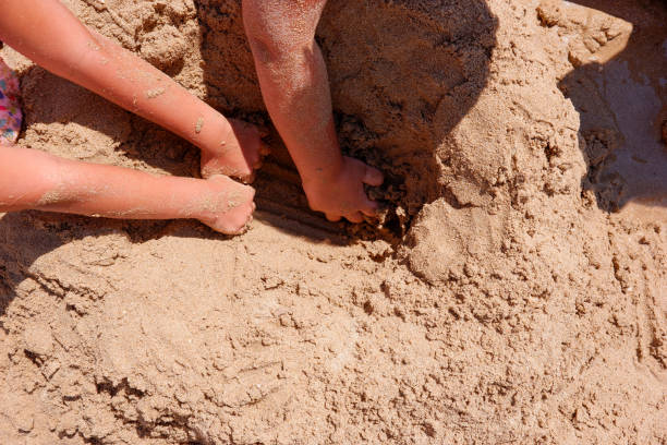istock Children digging a hole at the beach. 1257913898