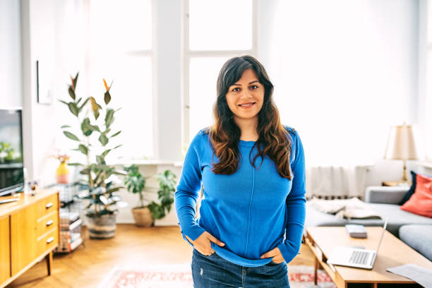 istock Confident woman standing in living room 1257914621